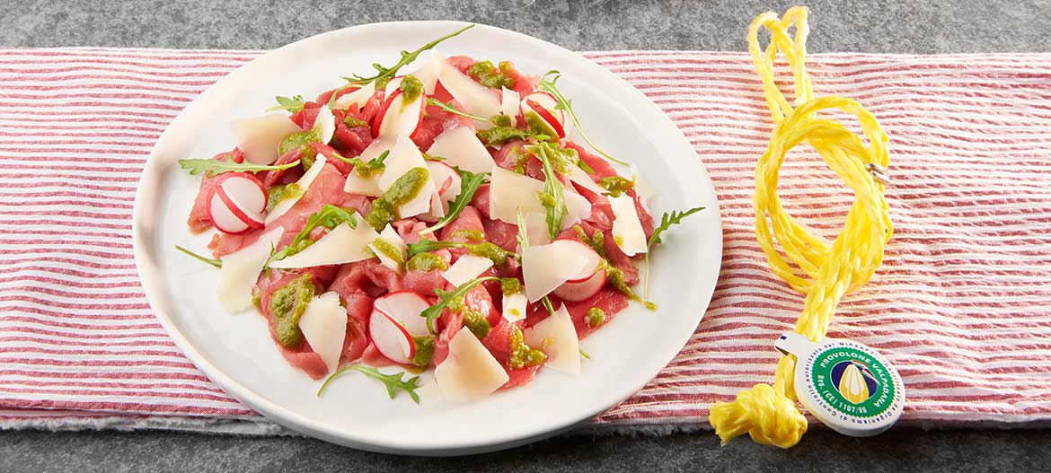 Carpaccio di manzo con Provolone Valpadana D.O.P. piccante e pesto di rucola|